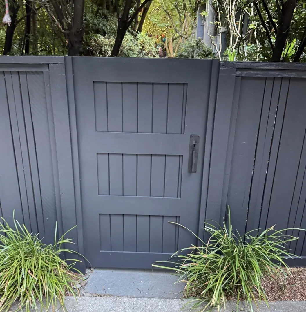 Charcoal painted three-panel side gate with matching board and batten fence panels