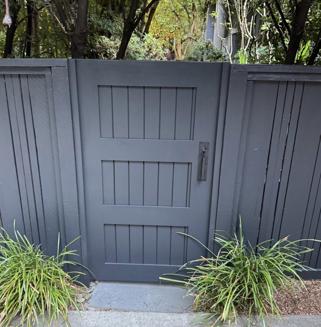 Charcoal painted three-panel side gate with matching board and batten fence panels