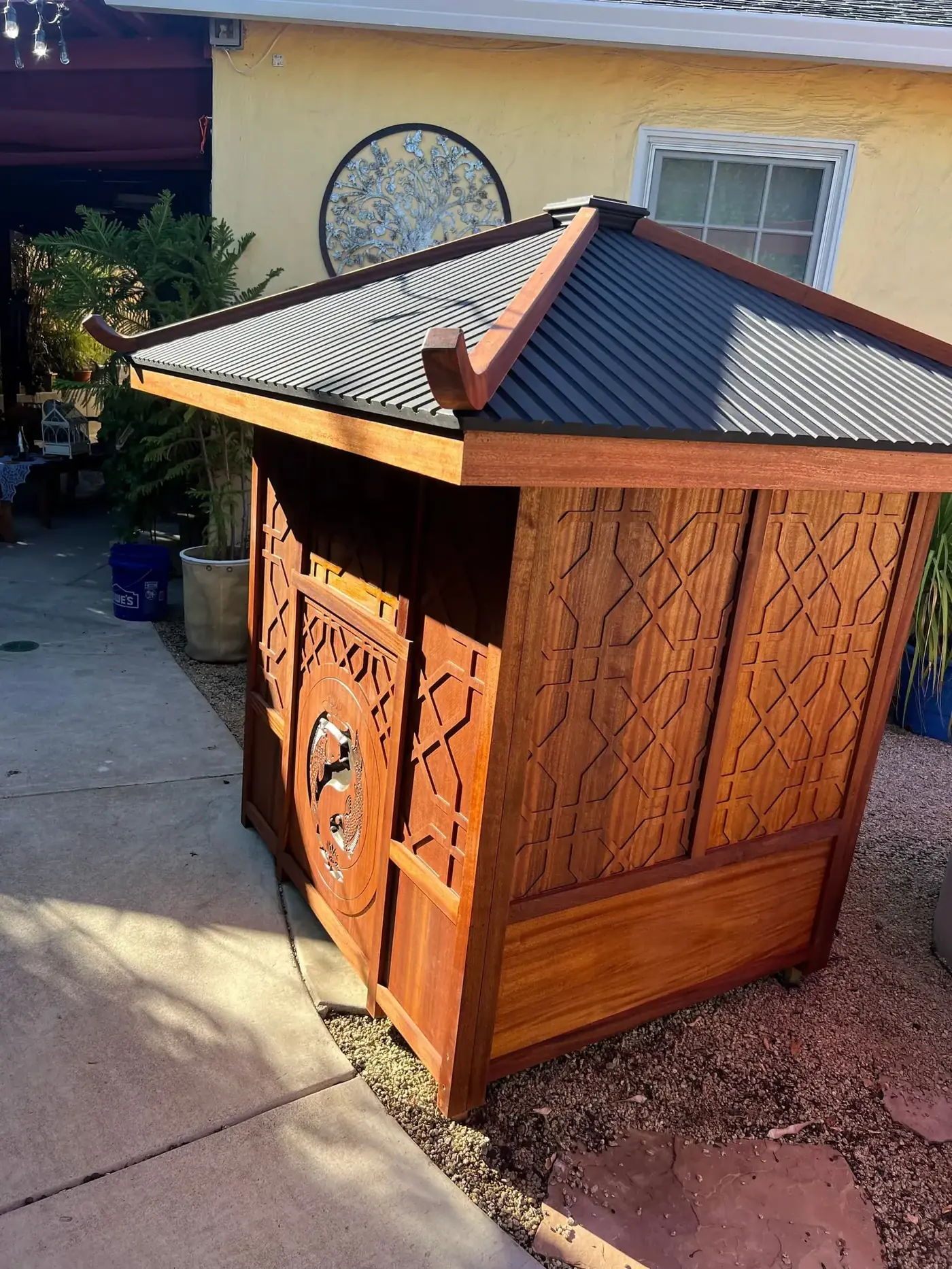 Handcrafted Japanese-inspired sapele pagoda with metal roof and lattice carvings