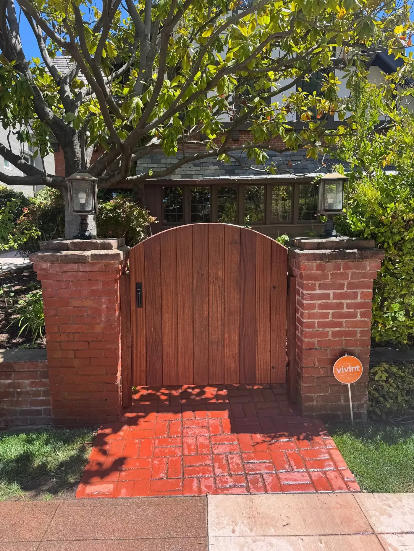 Arched mahogany single swing gate with iron handle